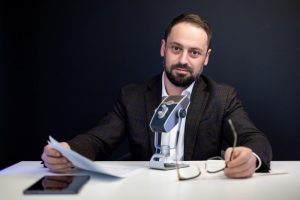 muzhchina-v-delovom-kostjume-vedet-transljaciju-s-mikrofonom мужчина в деловом костюме ведет трансляцию с микрофоном