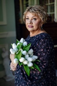 zhenshhina-s-buketom-tjul’panov-stoit-u-okna женщина с букетом тюльпанов стоит у окна